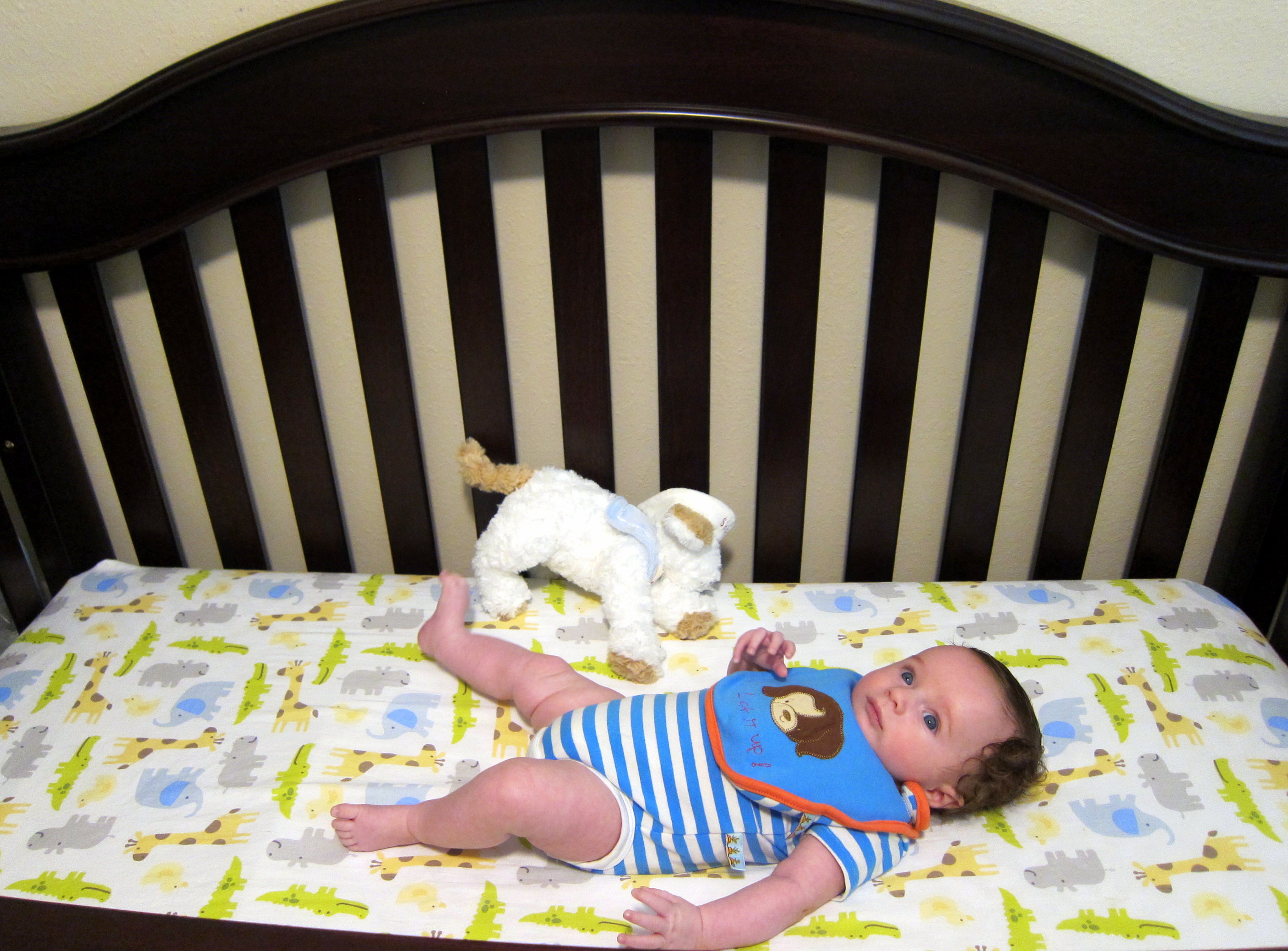 Charlie in his 4 in one crib, which has a higher setting for infants, lower setting for standers, and can be used as a toddler and big kid bed.